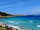 Den vackra badstranden åt väster, till höger syns Bonifacio, på Corsica som har färjeförbindelse med Santa Teresa Gallura.
